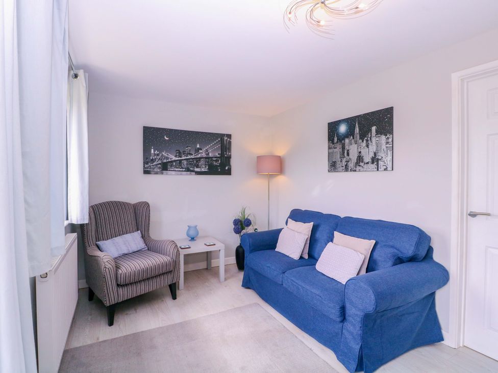 A living room with a sofa and armchair at Sunny Cottage in Brecon
