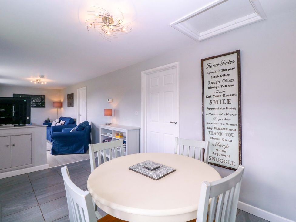 A living room with a table and chairs and a sofa at Sunny Cottage in Brecon