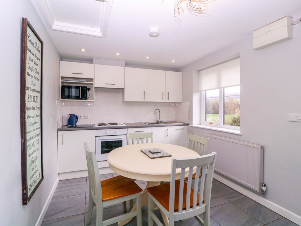 A kitchen with a table and chairs at Sunny Cottage in Brecon