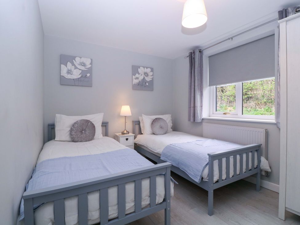 A bedroom with two beds and a lamp at Sunny Cottage in Brecon