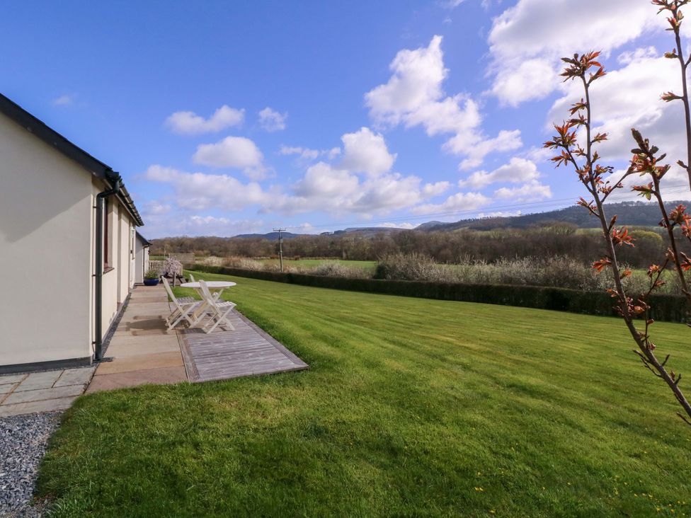 A garden with a table and chairs at Sunny Cottage in Brecon