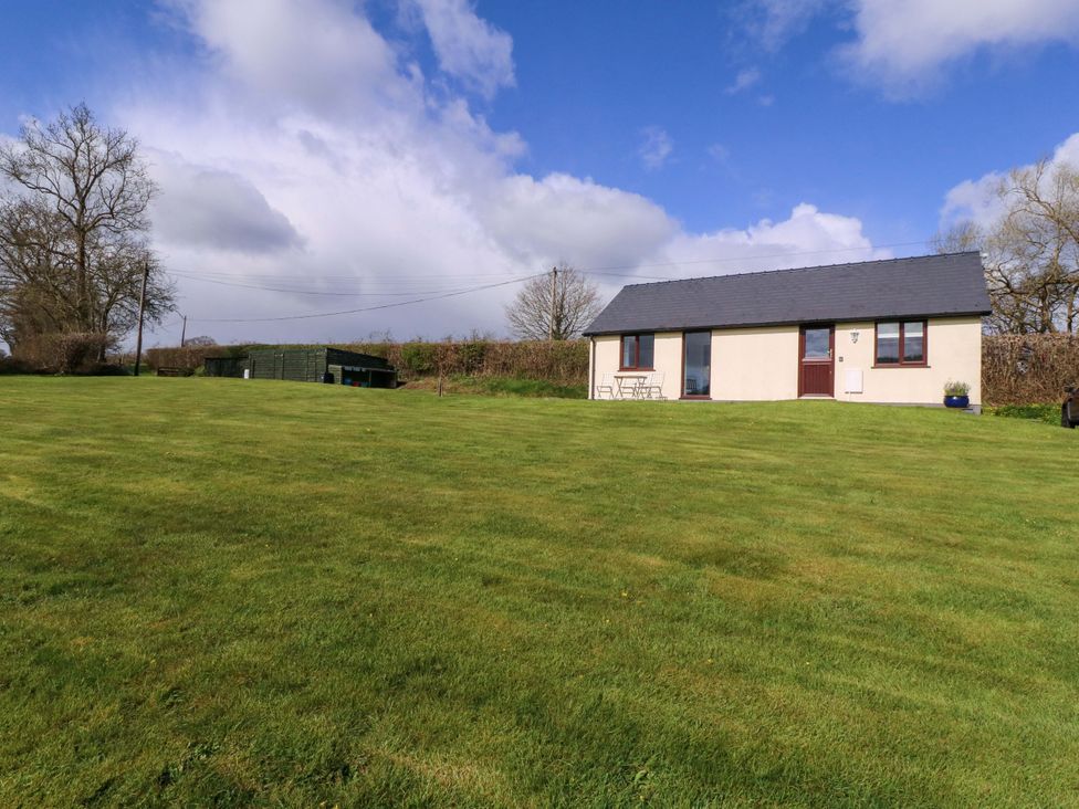 A house with a table and chairs on a lawn at Sunny Cottage in Brecon