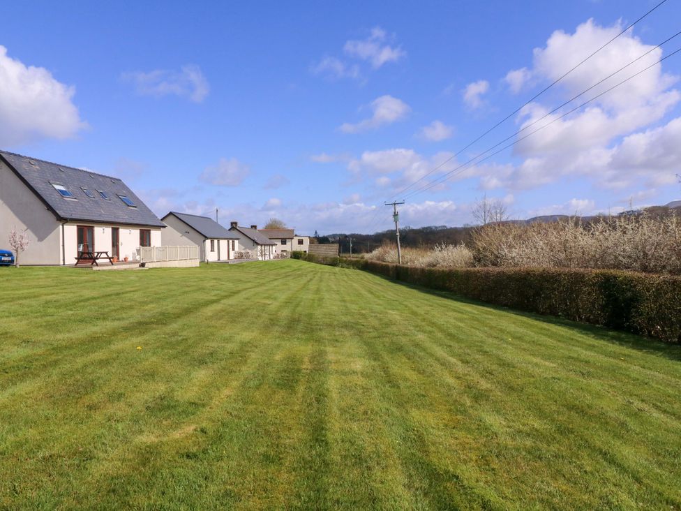 An outdoor view of houses and lawn at Sunny Cottage in Brecon
