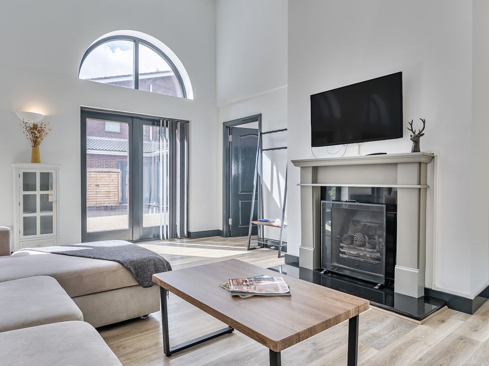 A living room with a coffee table and television at The Annex in Wimborne Minster