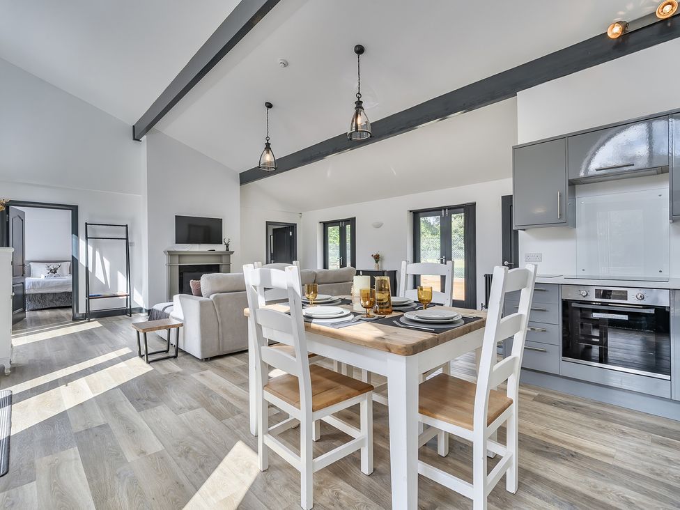 An open plan living and dining area with a dining table and kitchen at The Annex Wimborne Minster