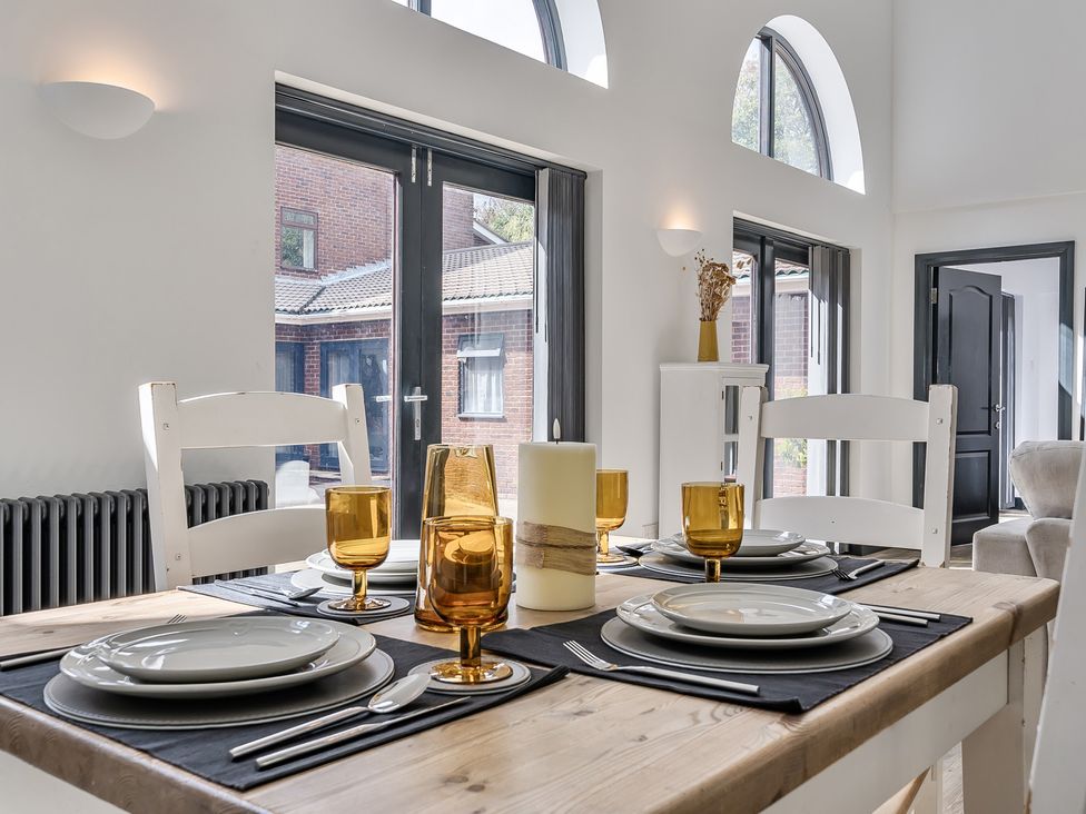 A dining room with a table set for dinner at The Annex Wimborne Minster