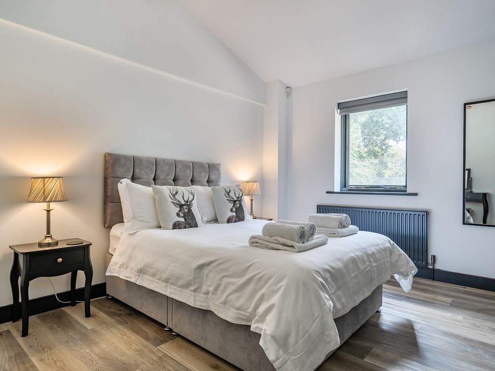 A bedroom with a bed, nightstand, and lamp at The Annex in Wimborne Minster