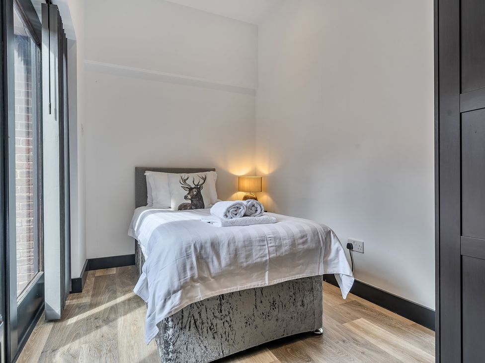 A bedroom with a bed and lamp at The Annex in Wimborne Minster
