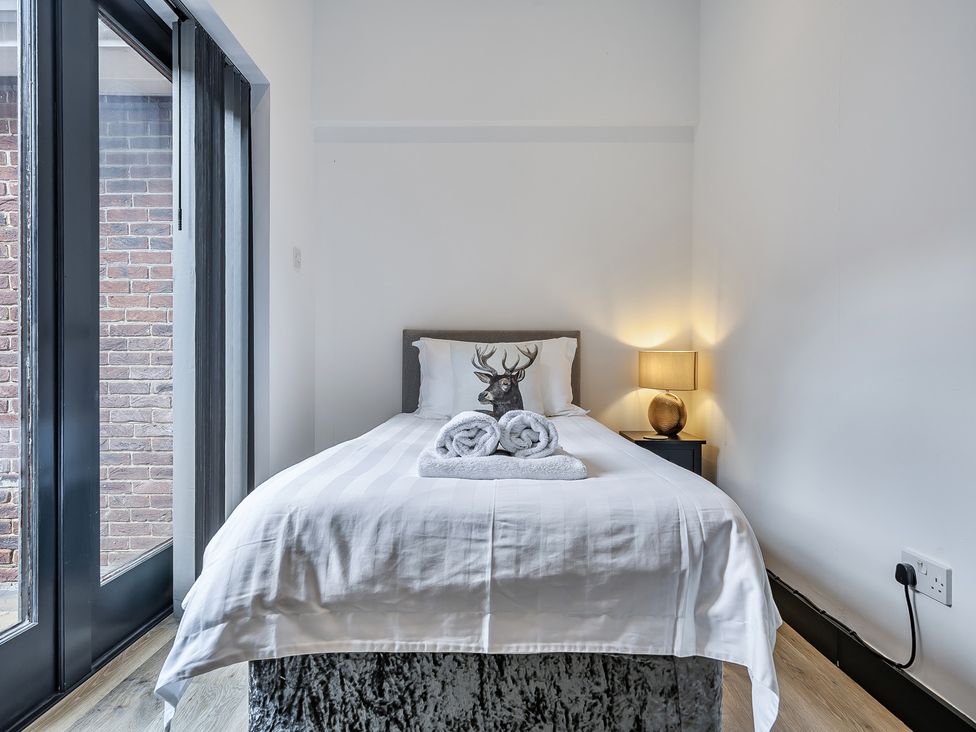 A bedroom with a single bed and a lamp at The Annex in Wimborne Minster