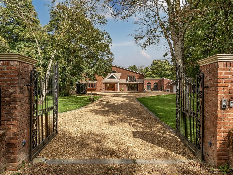 A property entrance with a gravel path and trees at The Annex in Wimborne Minster