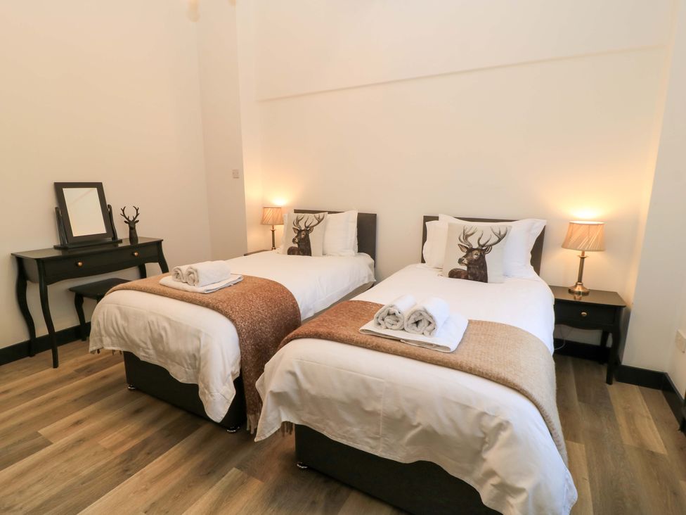 A bedroom with two beds and a table at The Annex in Wimborne Minster
