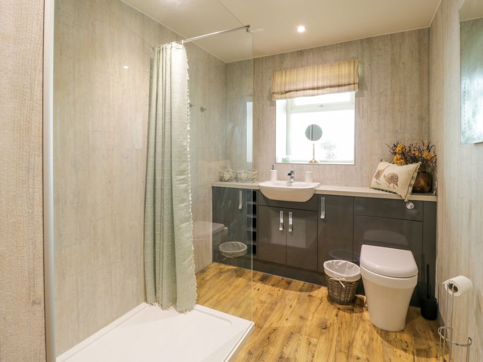 A bathroom with shower, toilet and wash basin at Nithbank Cottage in 