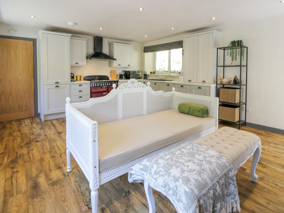 A kitchen with cabinets and a stove at Nithbank Cottage