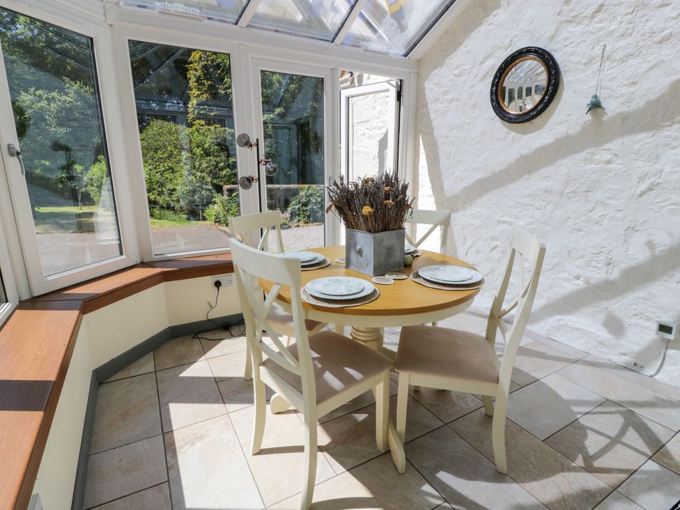 A dining table with chairs and decorative pot at Nithbank Cottage