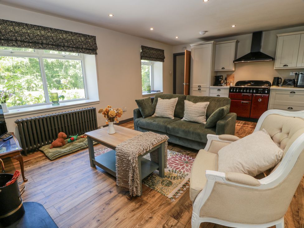 A living room with a sofa and armchair at Nithbank Cottage Thornhill