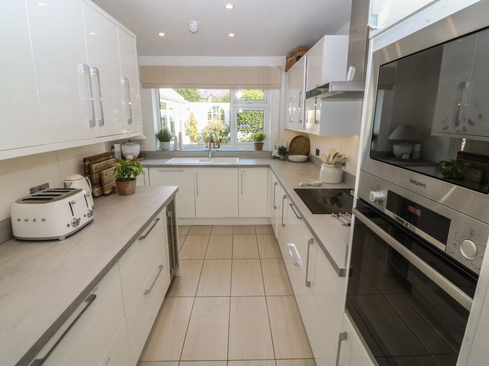A kitchen with cabinets, sink, and appliances at Trem Ynys in Mynytho near Abersoch