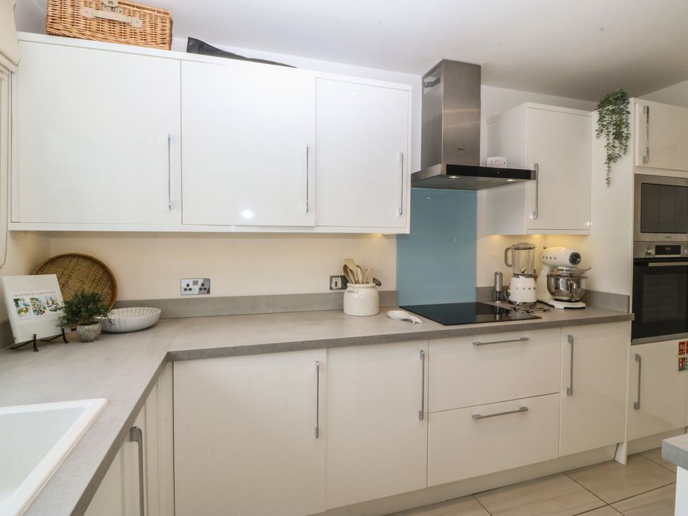 A kitchen featuring cabinets, a sink, and various appliances at Trem Ynys in Mynytho near Abersoch