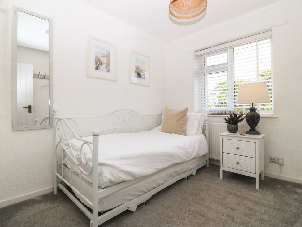 A bedroom with a bed and nightstand at Trem Ynys in Mynytho near Abersoch