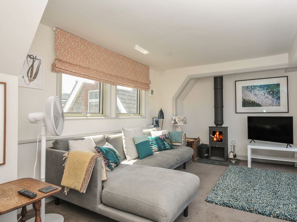 A living room with a sofa and television at The Lookout in Polzeath