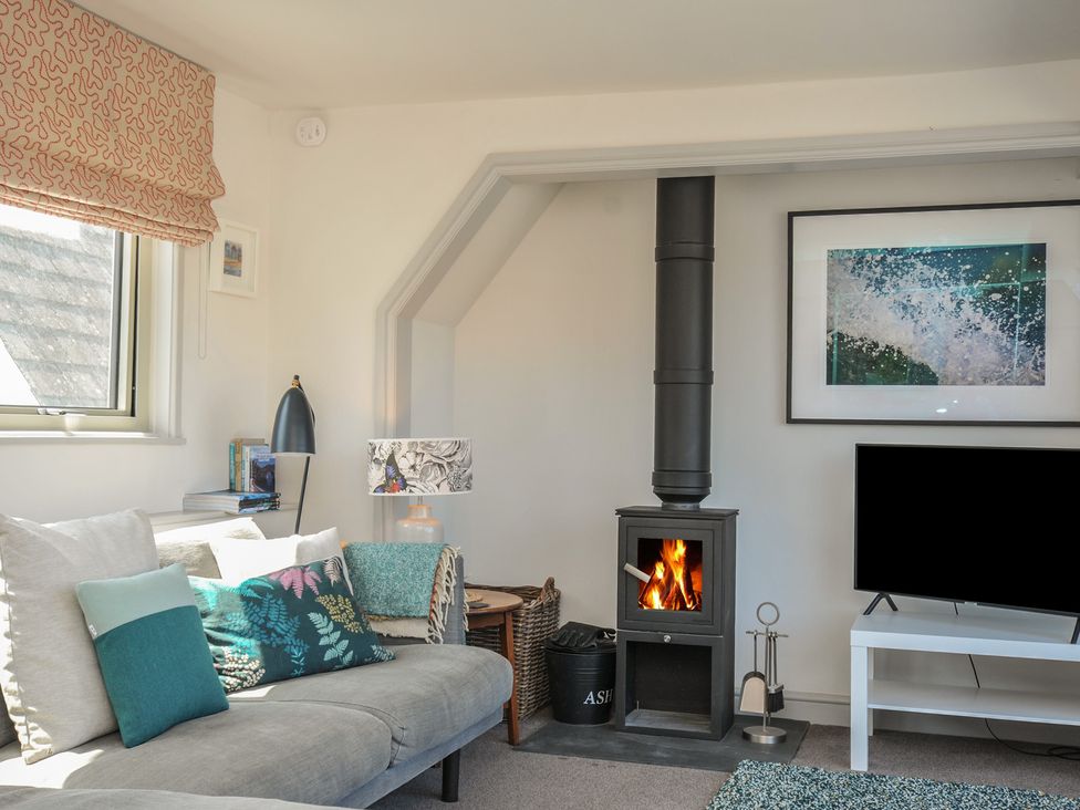A living room with a wood stove and television at The Lookout in Polzeath