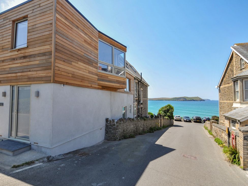 A house by the ocean and road with parked cars at The Lookout in Polzeath