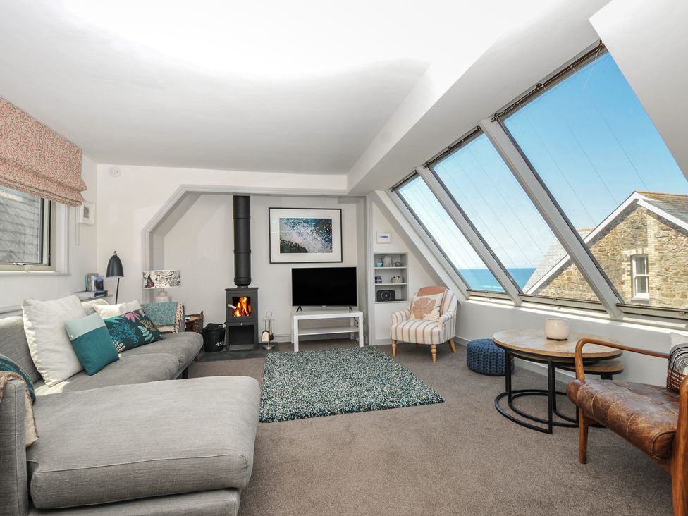 A living room with a sofa and television at The Lookout in Polzeath