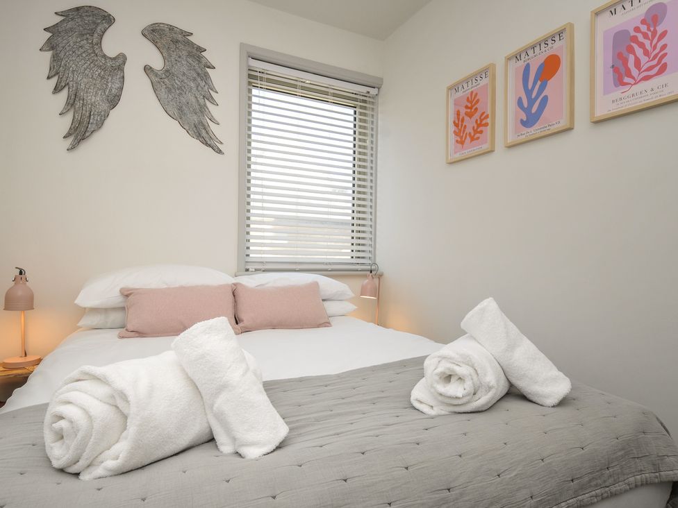 A bedroom with a bed and wall art at The Lookout in Polzeath