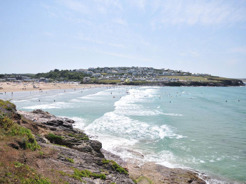 A beach with people and waves at The Lookout in Polzeath