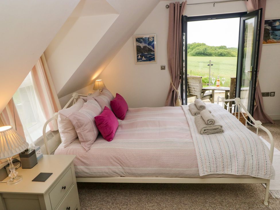 A bedroom with a bed and a view to the outside at North Studdock Cottage Angle near Pembroke