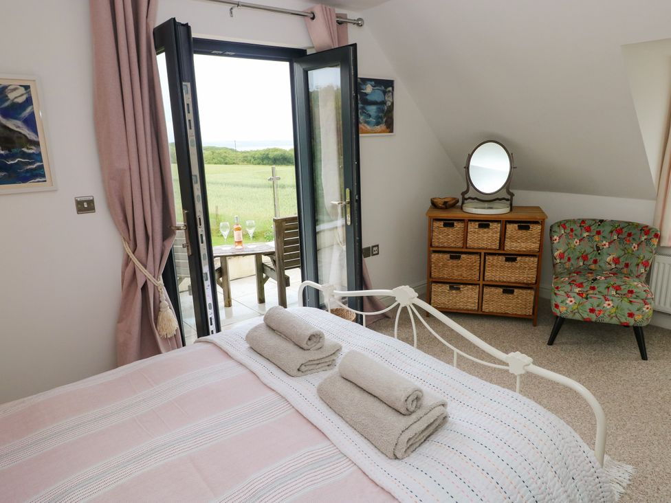 A bedroom with a bed, dresser, and mirror at North Studdock Cottage near Pembroke
