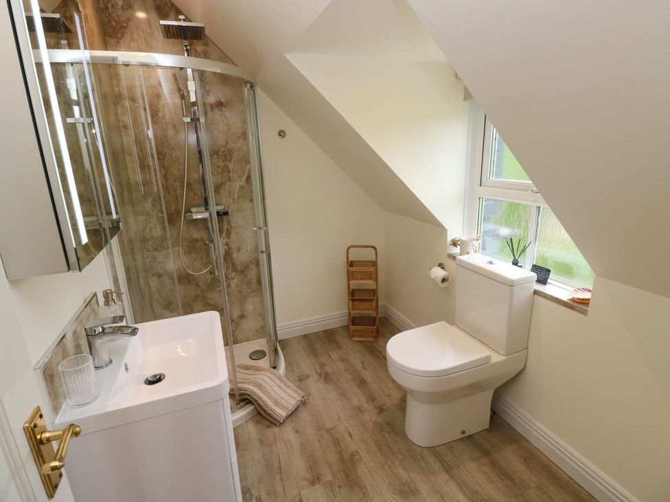 A bathroom with a shower, sink and toilet at North Studdock Cottage in Angle near Pembroke