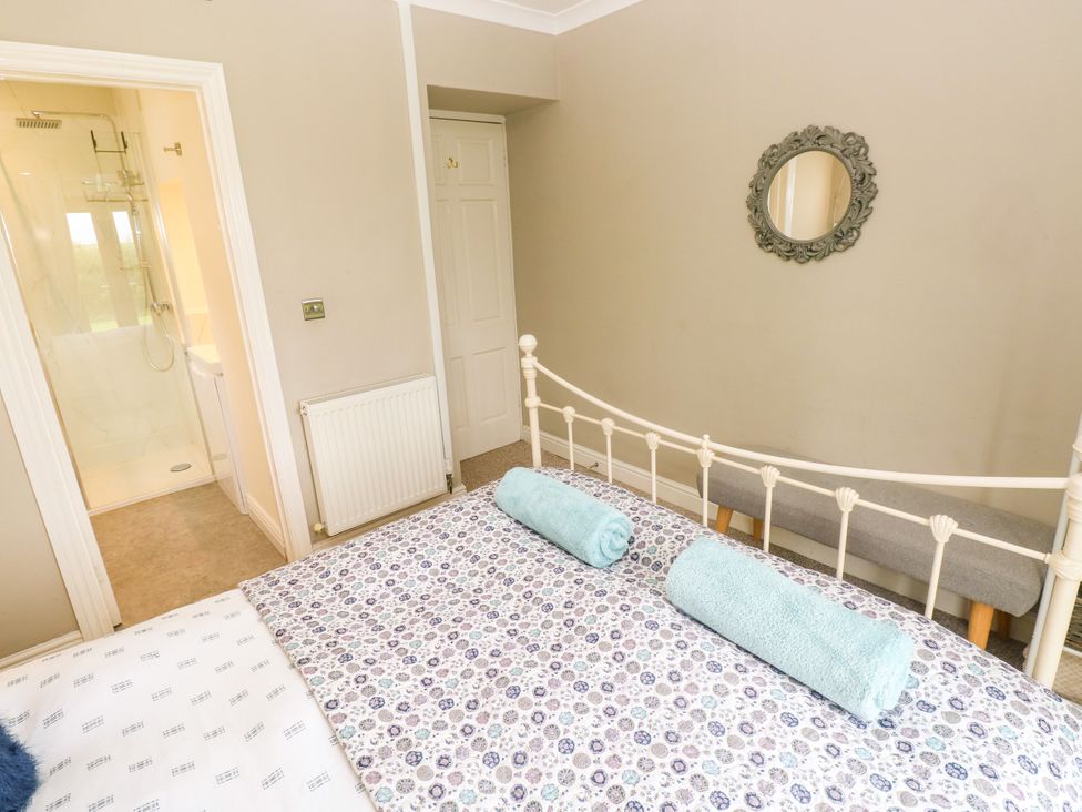 A bedroom with a bed and towels at North Studdock Cottage in Angle near Pembroke