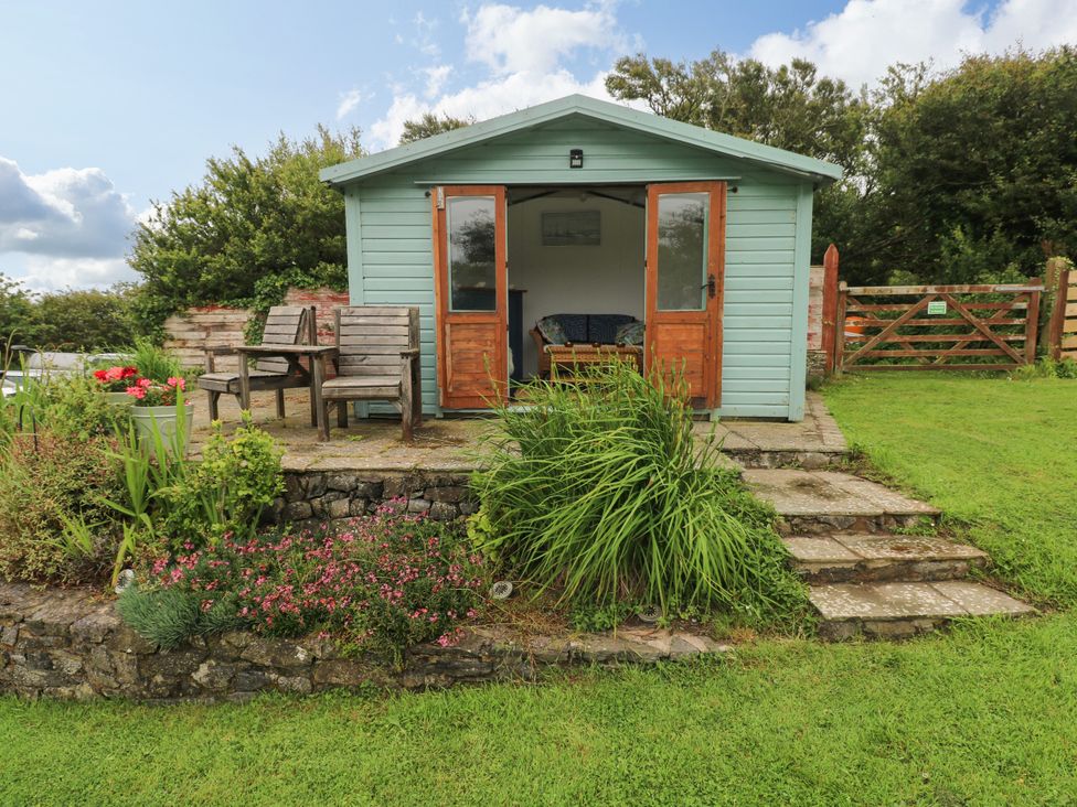 A cabin with outdoor seating in the garden at North Studdock Cottage Angle near Pembroke