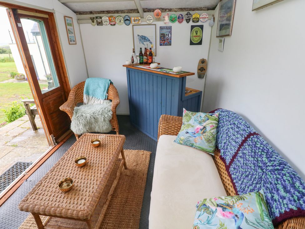 A snug with wicker furniture and a bar counter at North Studdock Cottage Angle near Pembroke