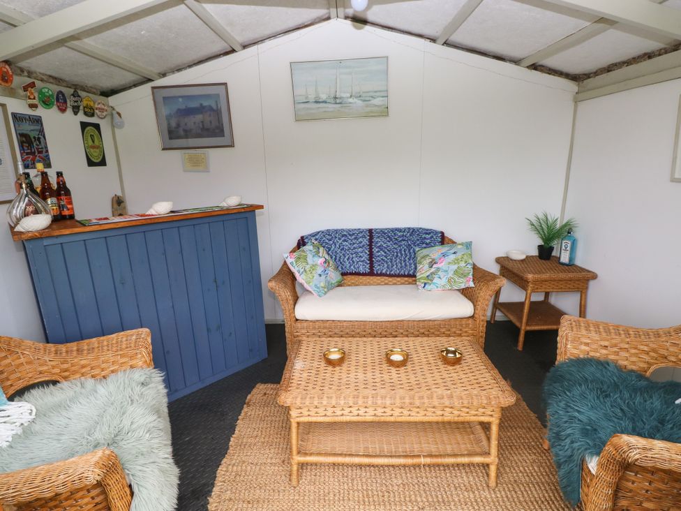 A snug with wicker furniture and a bar counter at North Studdock Cottage Angle near Pembroke