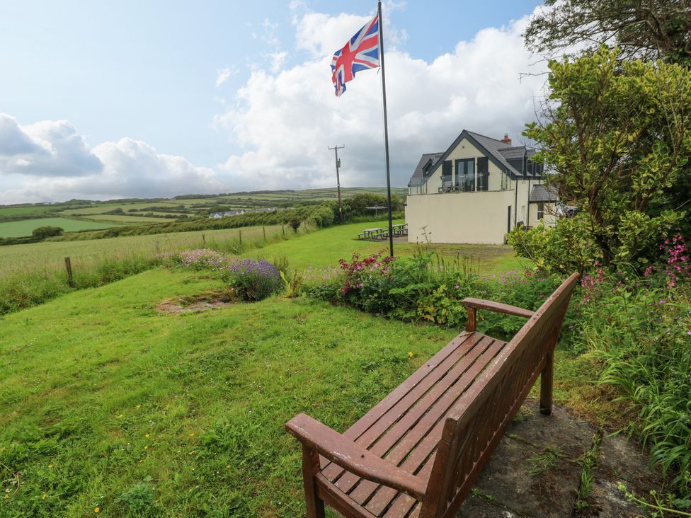 A garden with a bench and a flag at North Studdock Cottage in Angle near Pembroke
