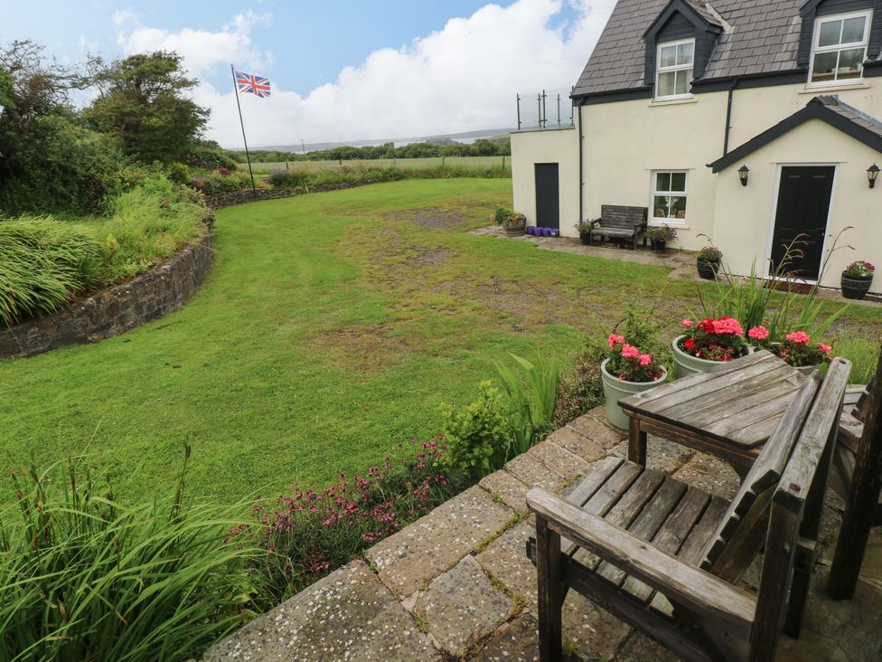 An outdoor area with a garden and a house at North Studdock Cottage in Angle near Pembroke
