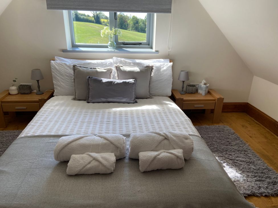 A bedroom with a bed and side tables at Postbox Cottage Atlow near Ashbourne