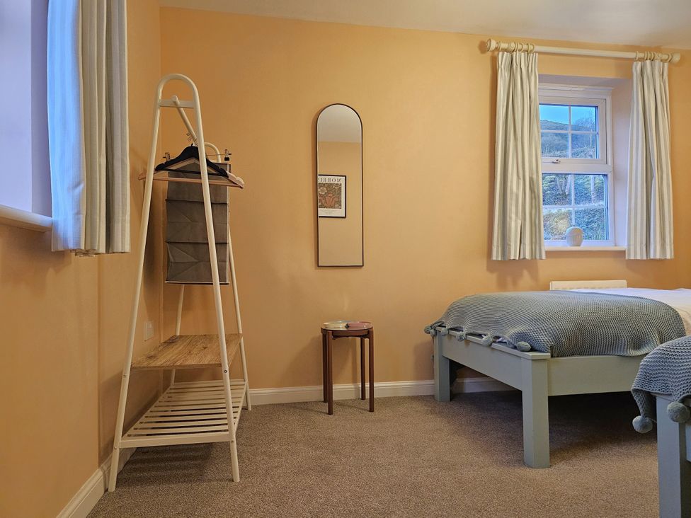 A bedroom with a bed and mirror at The Milne in Todmorden