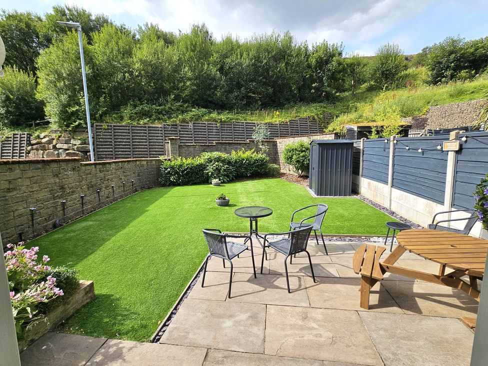A garden with artificial grass and seating area at The Milne in Todmorden