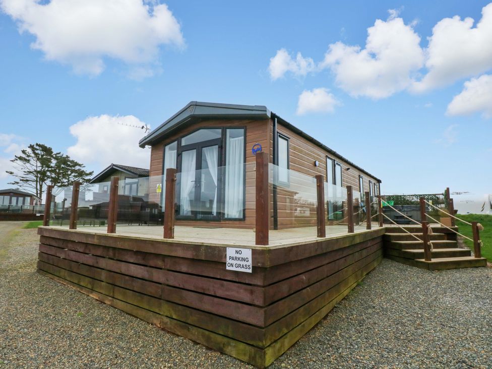 A holiday lodge with decking and steps at Oyster Lodge in Little Haven