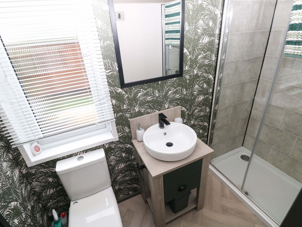 A bathroom with a sink and shower at Oyster Lodge in Little Haven