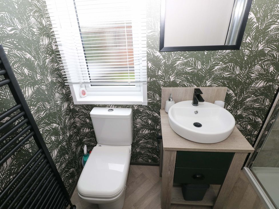 A bathroom with a toilet and sink at Oyster Lodge in Little Haven