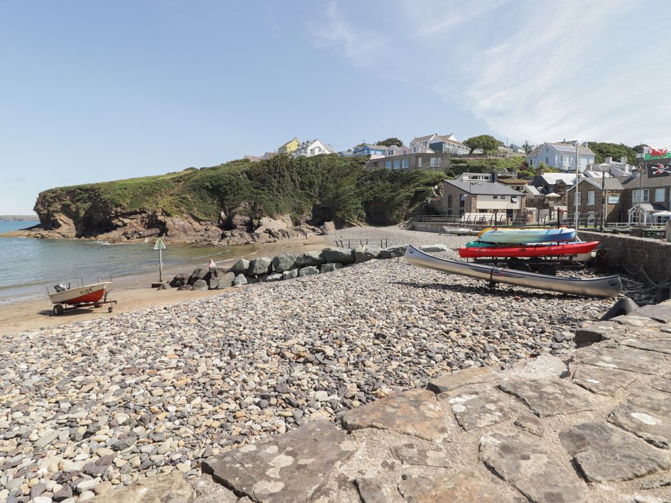 A beach with boats and houses at Driftwood Lodge Hasguard Cross near Broad Haven
