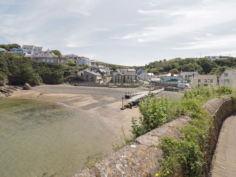 A beach with houses and a pier at Driftwood Lodge Hasguard Cross near Broad Haven