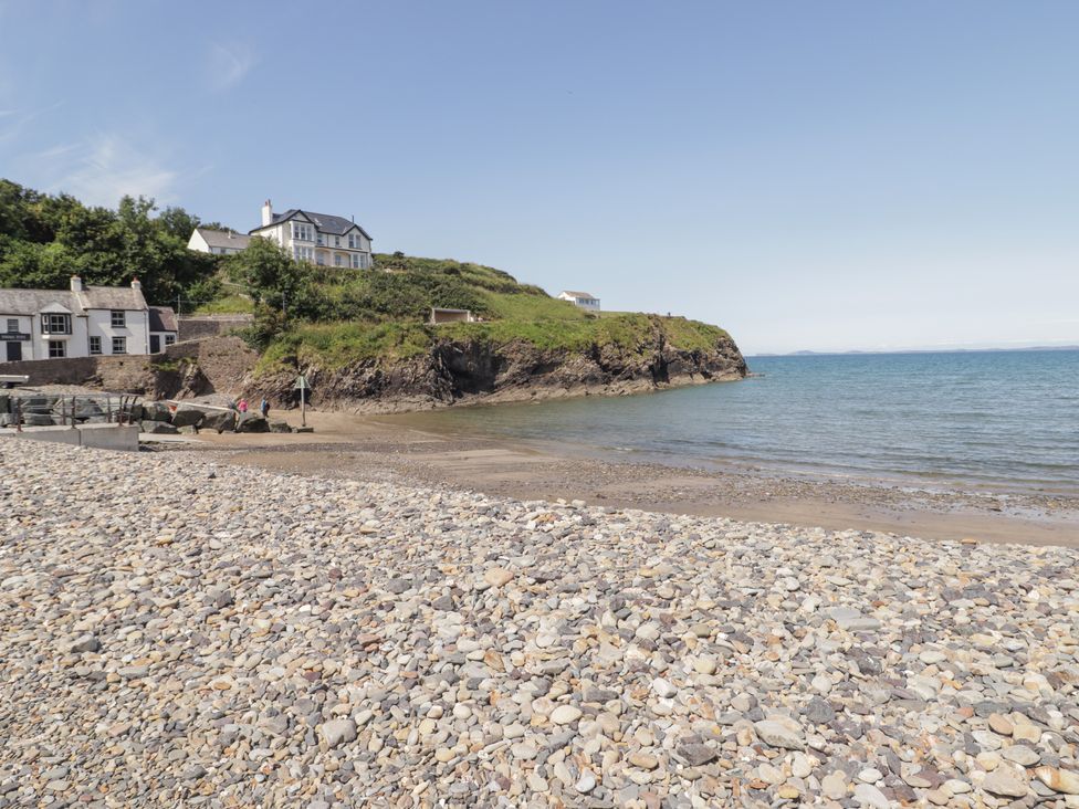A beach with rocks and houses near the water at Driftwood Lodge Hasguard Cross near Broad Haven