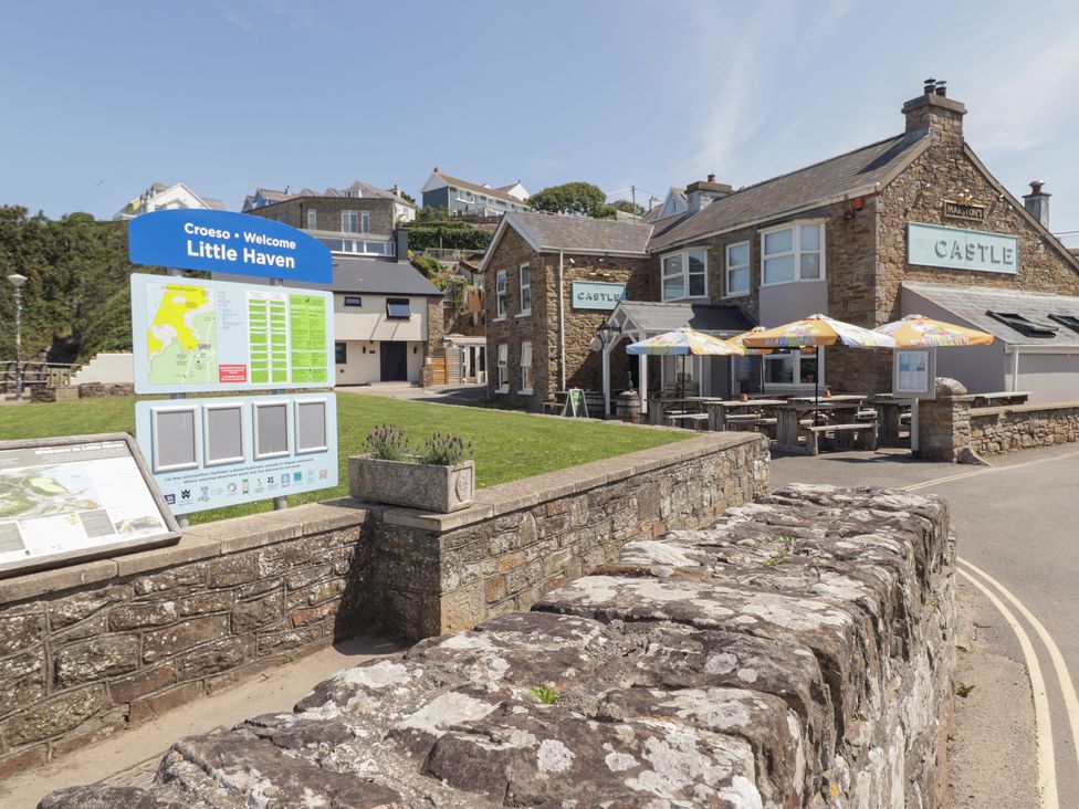 An outdoor view of the Castle pub and welcome sign at Driftwood Lodge Hasguard Cross near Broad Haven