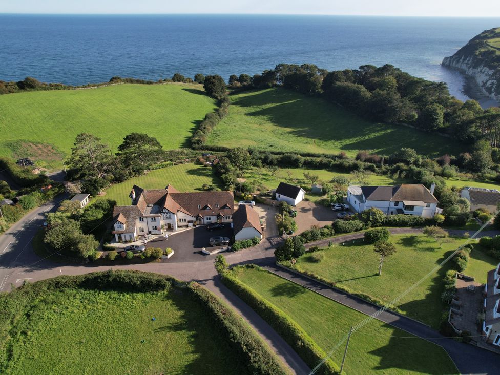 An aerial view of houses surrounded by green fields near the coast at The Beach House in Beer