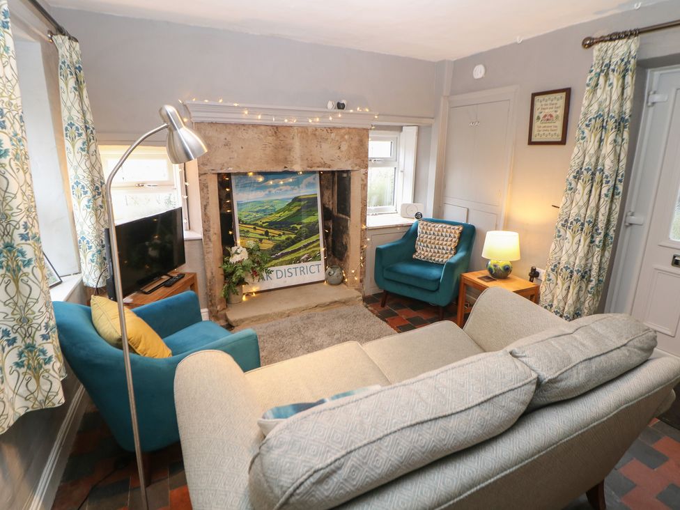 A living room with a sofa and armchairs at East Bank Cottage in Winster