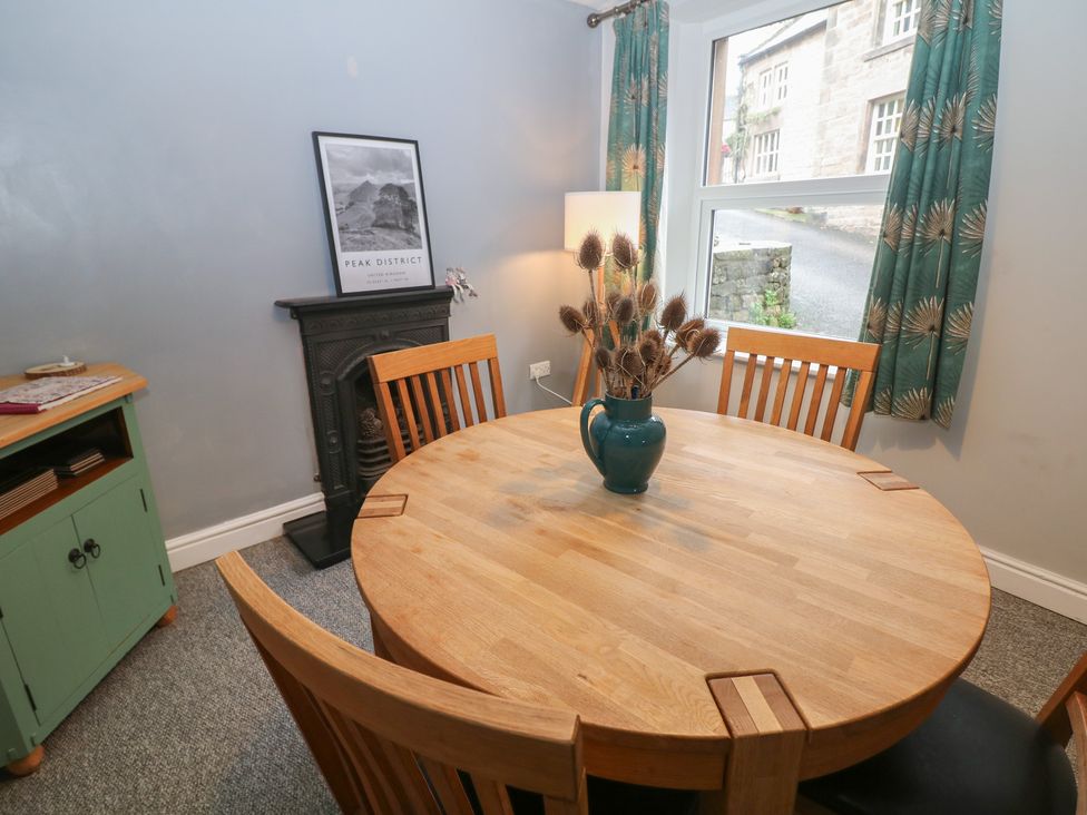 A dining room with a round table and chairs at East Bank Cottage in Winster